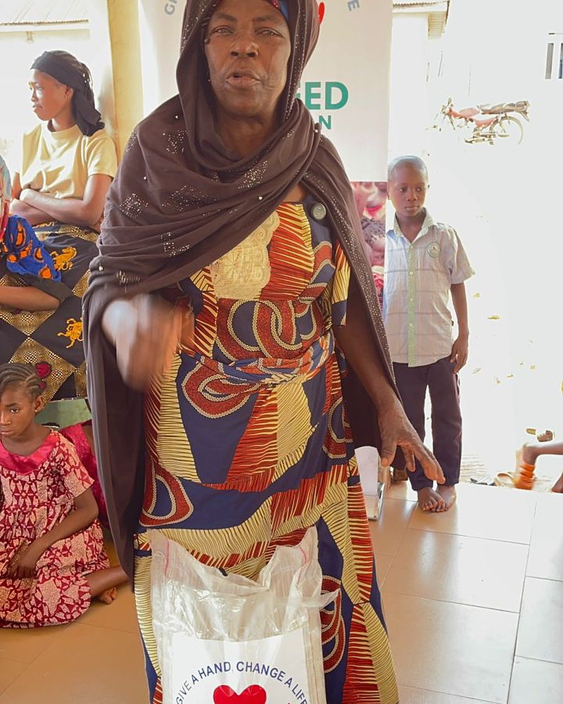 A woman holding a bag of food supplies received from Al Sa'eed Humanitarian Foundation.